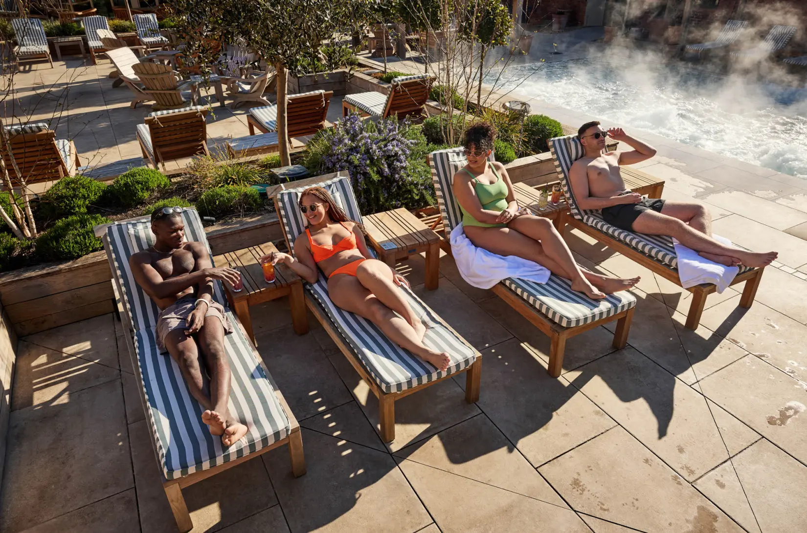 An image of people sunbathing by the pool at Eden Hall