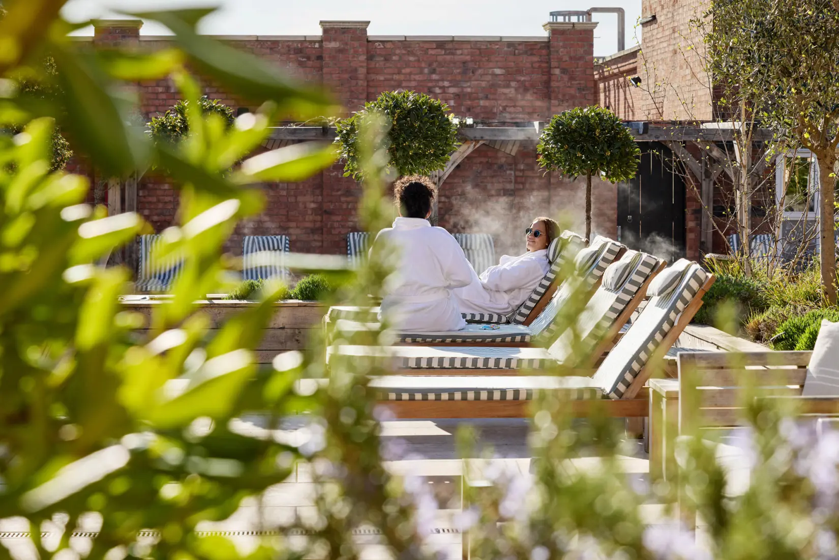 An image of two people on the sun loungers outside at Eden Hall