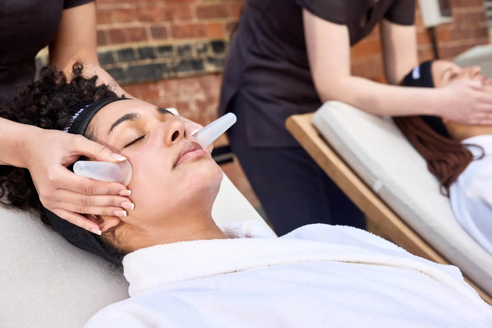 An image of two woman getting a face massage at Eden Hall