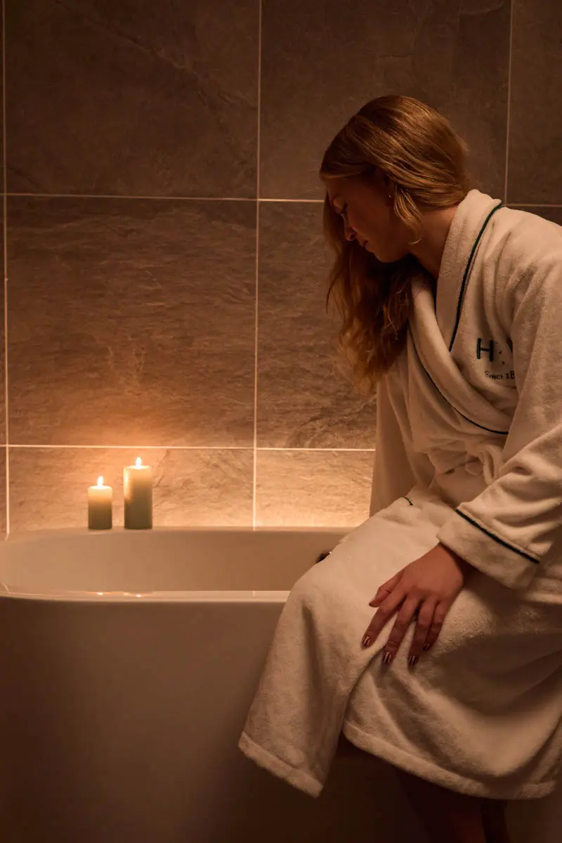 An image of a woman running a bath in one of the rooms at Hoar Cross Hall