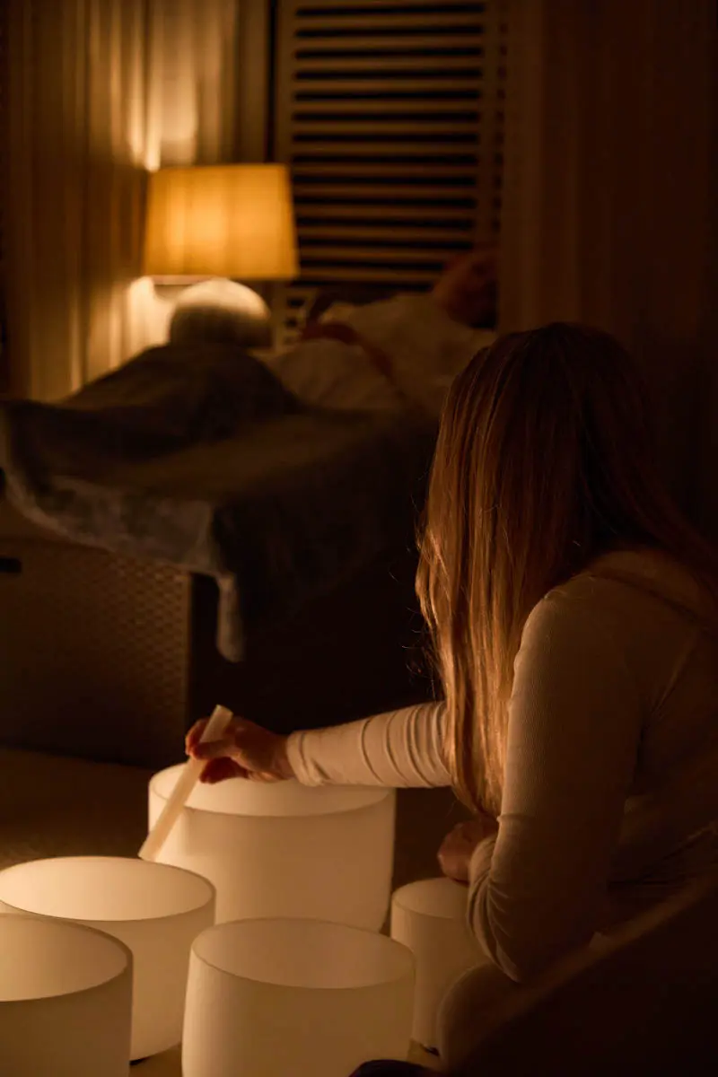 An image of a woman doing a sound bath treatment at Eden Hall