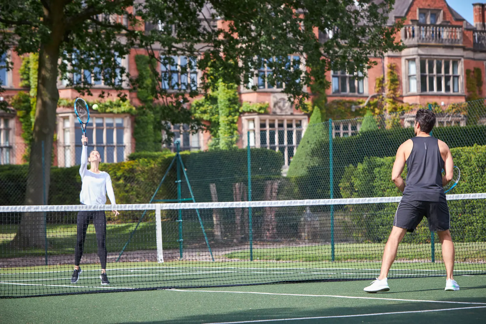 An image of people playing tennis at Hoar Cross Hall