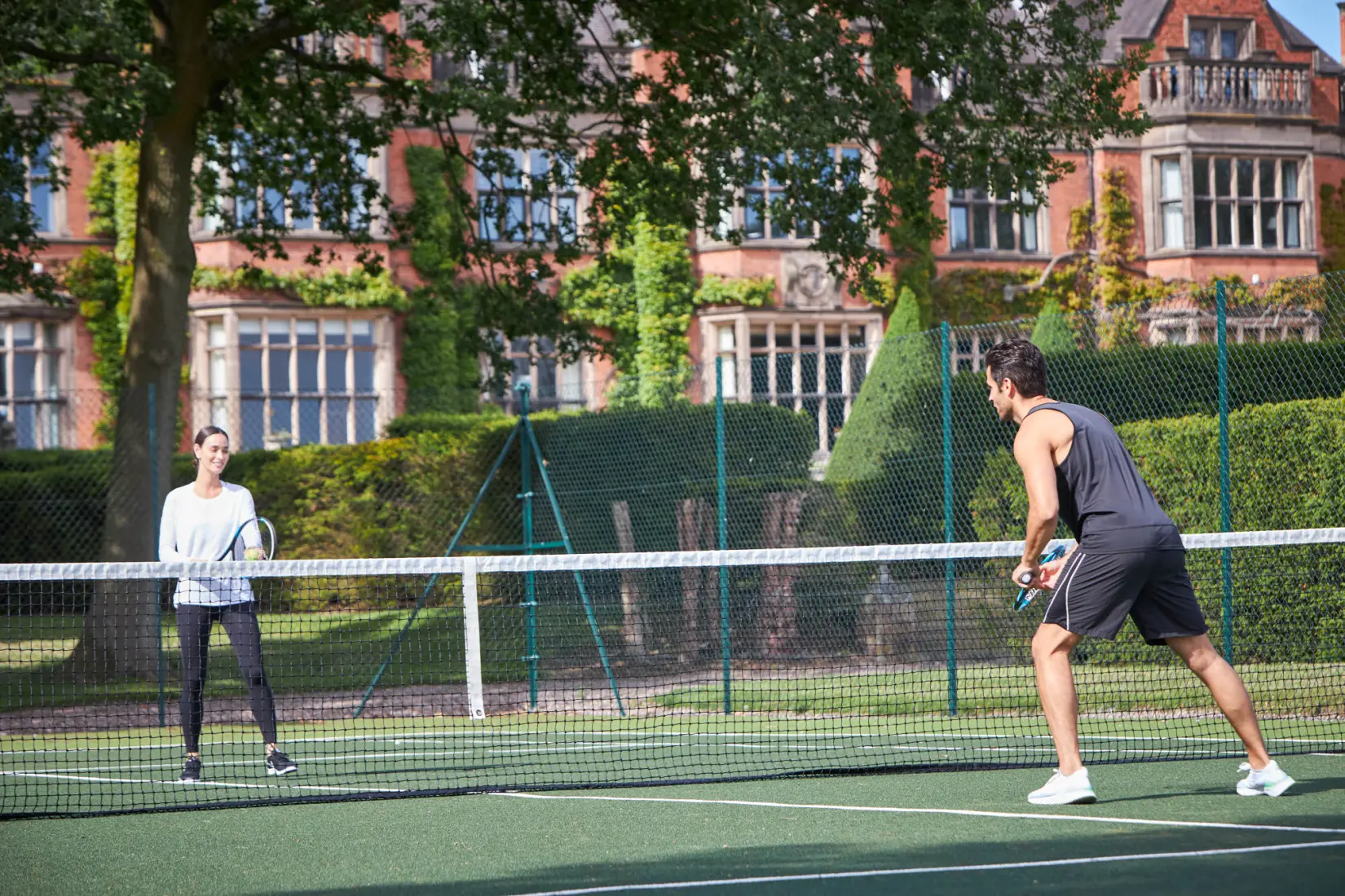 An image of people playing tennis at Hoar Cross Hall