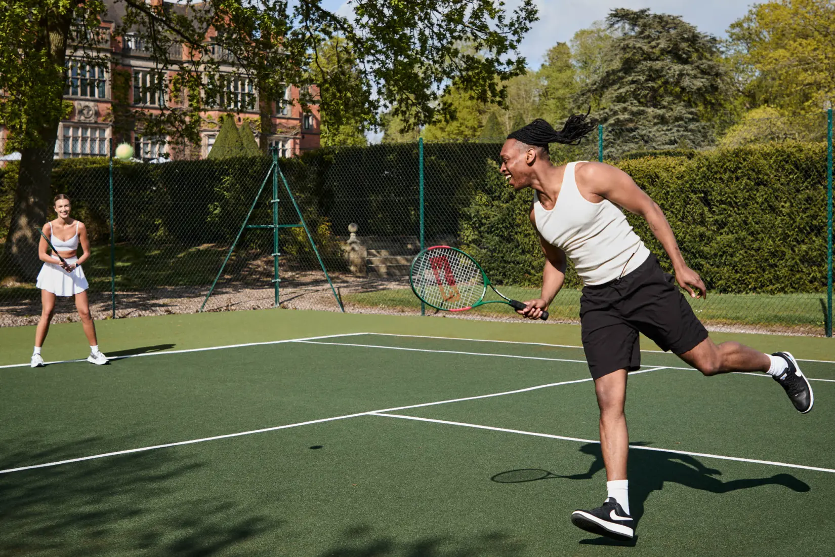 An image of people playing tennis at Hoar Cross Hall