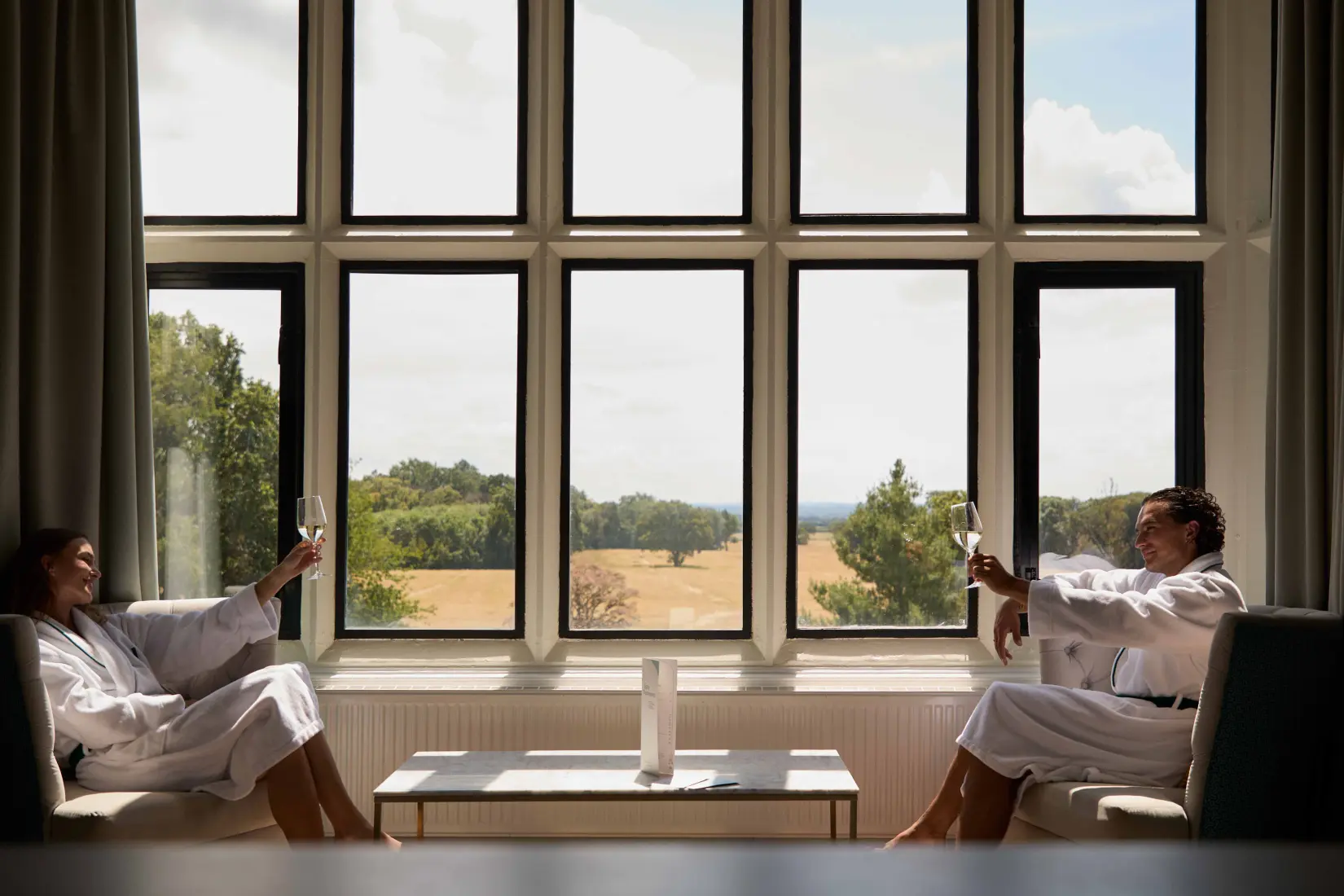 Two guests enjoying refreshments in a relaxation lounge with countryside views at Eden Hall Day Spa.