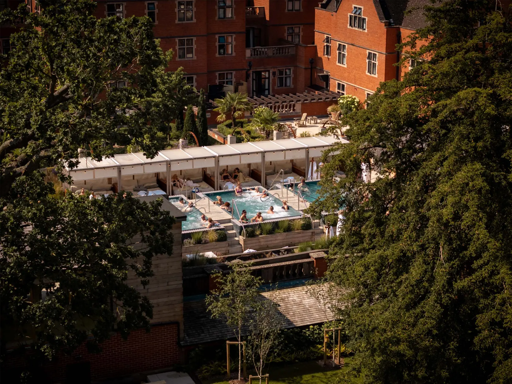 Outdoor pool and relaxation area with sun loungers set within landscaped gardens.
