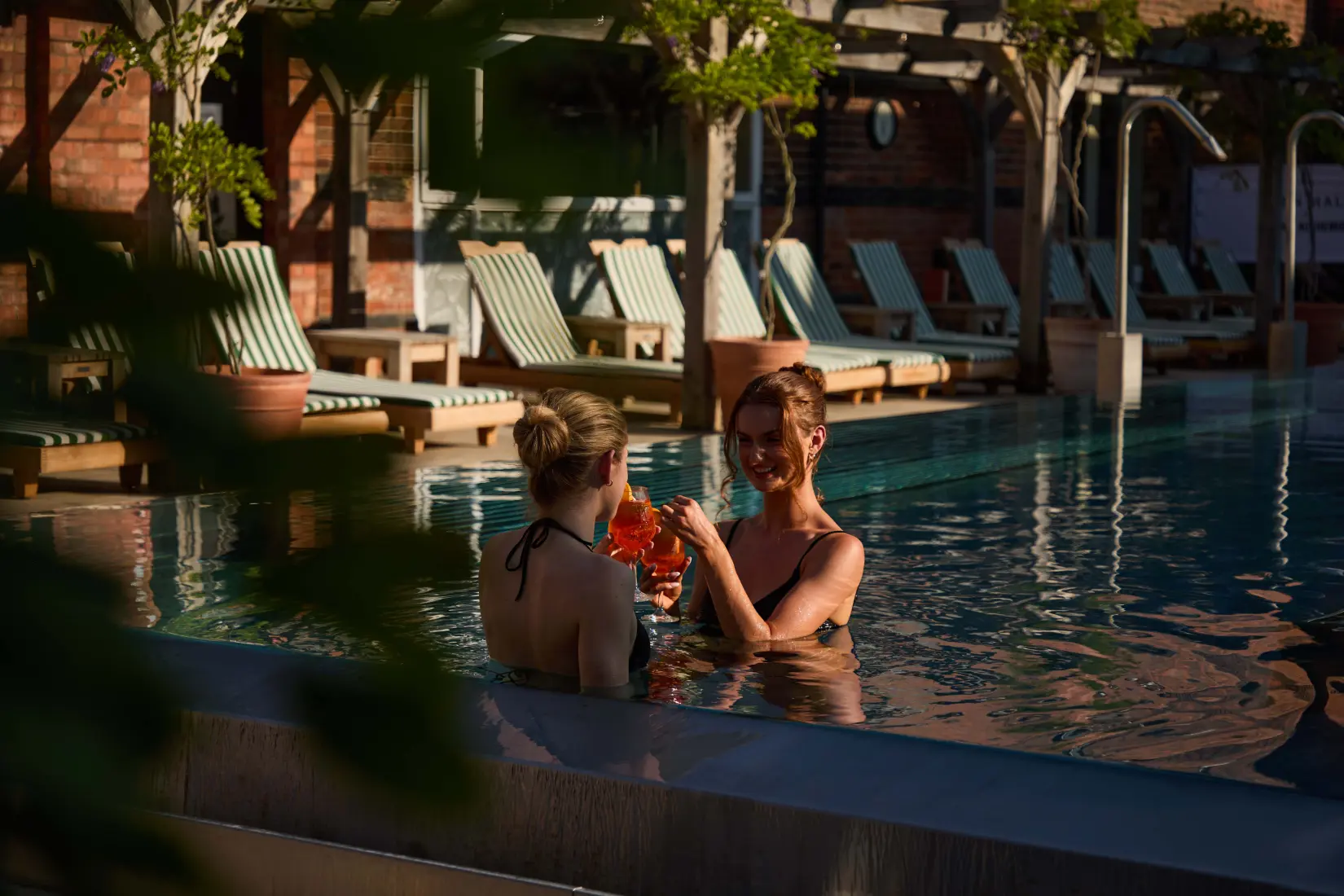 Outdoor hydrotherapy pool surrounded by loungers in the Eden Hall Spa Garden